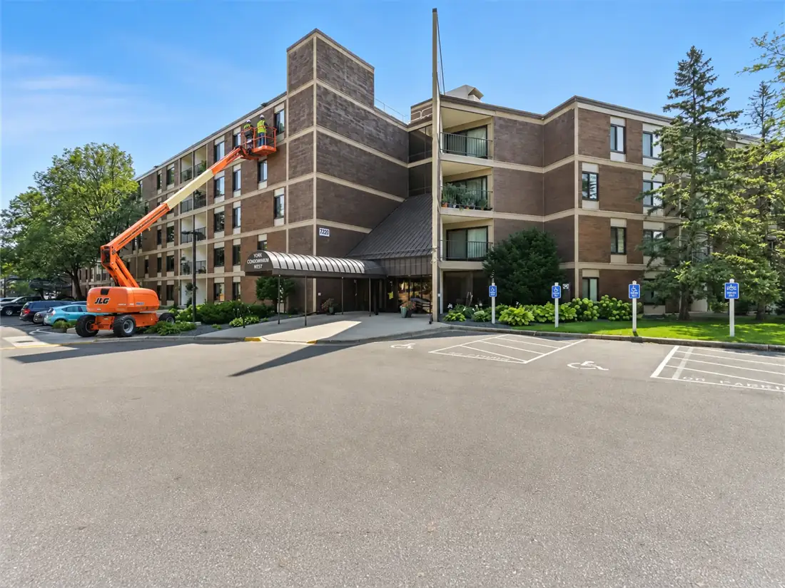 York Plaza condominium building in Edina with a boom lift at an upper-floor window during the window replacement